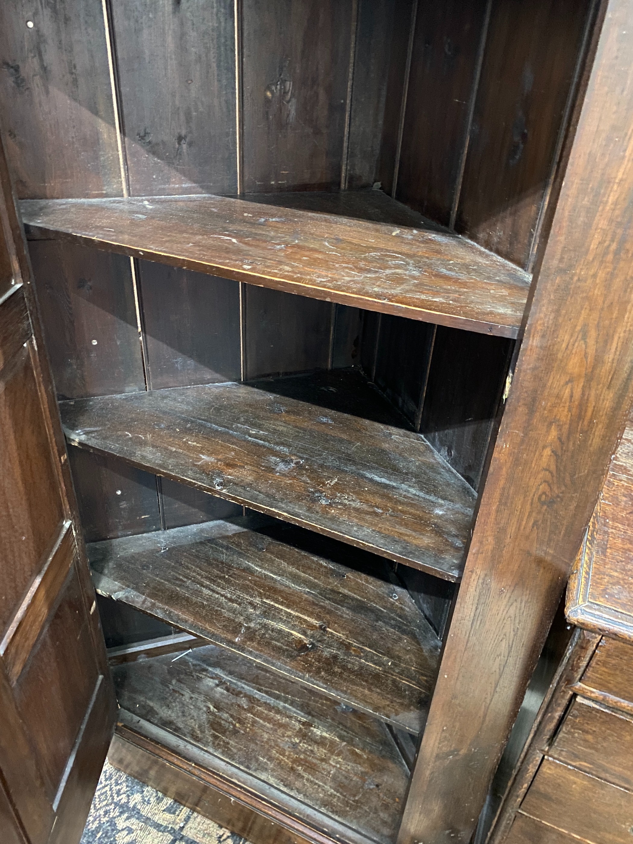 An 18th century style oak standing corner cupboard, enclosed by a full length door, width 94cm, depth 52cm, height 167cm